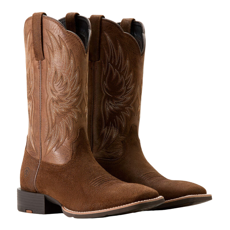 Pair of brown cowboy boots with intricate designs on a white background