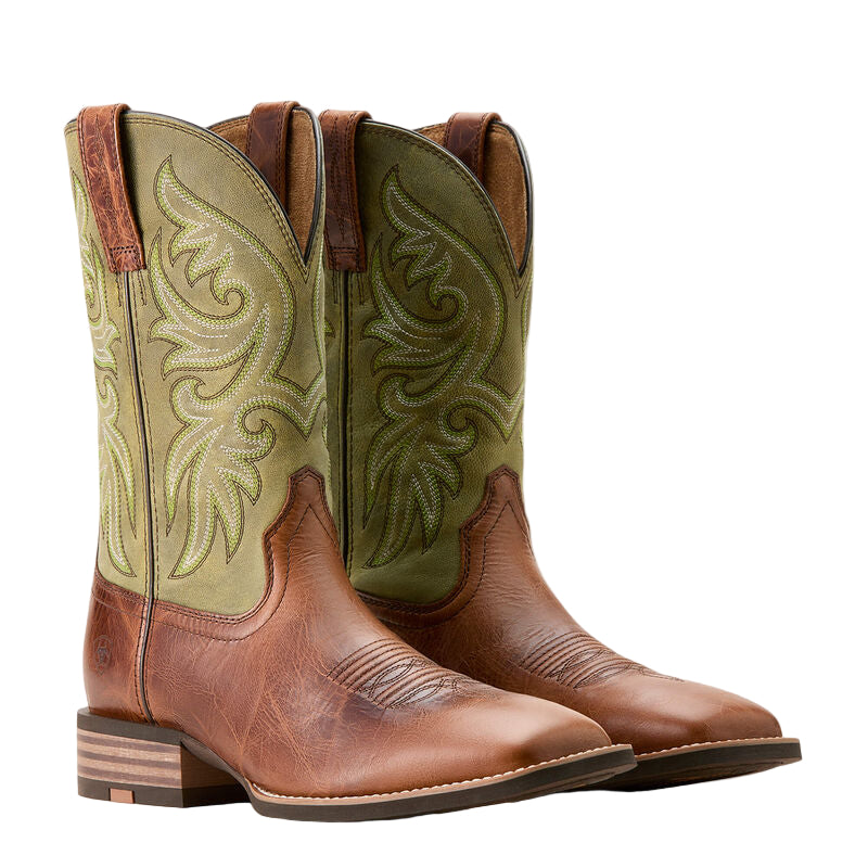 Pair of brown and green cowboy boots with intricate designs on a beige background
