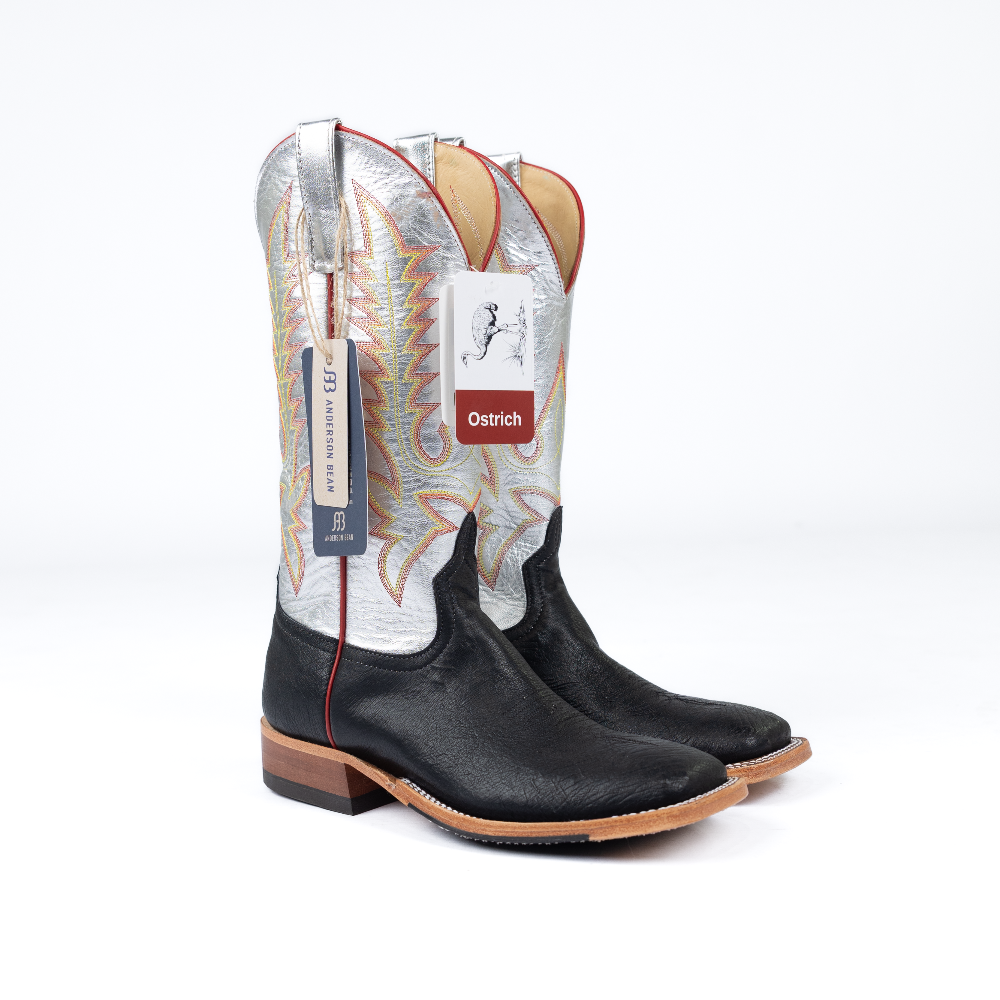Black cowboy boots with white interior and 'Ostrich' label on a white background