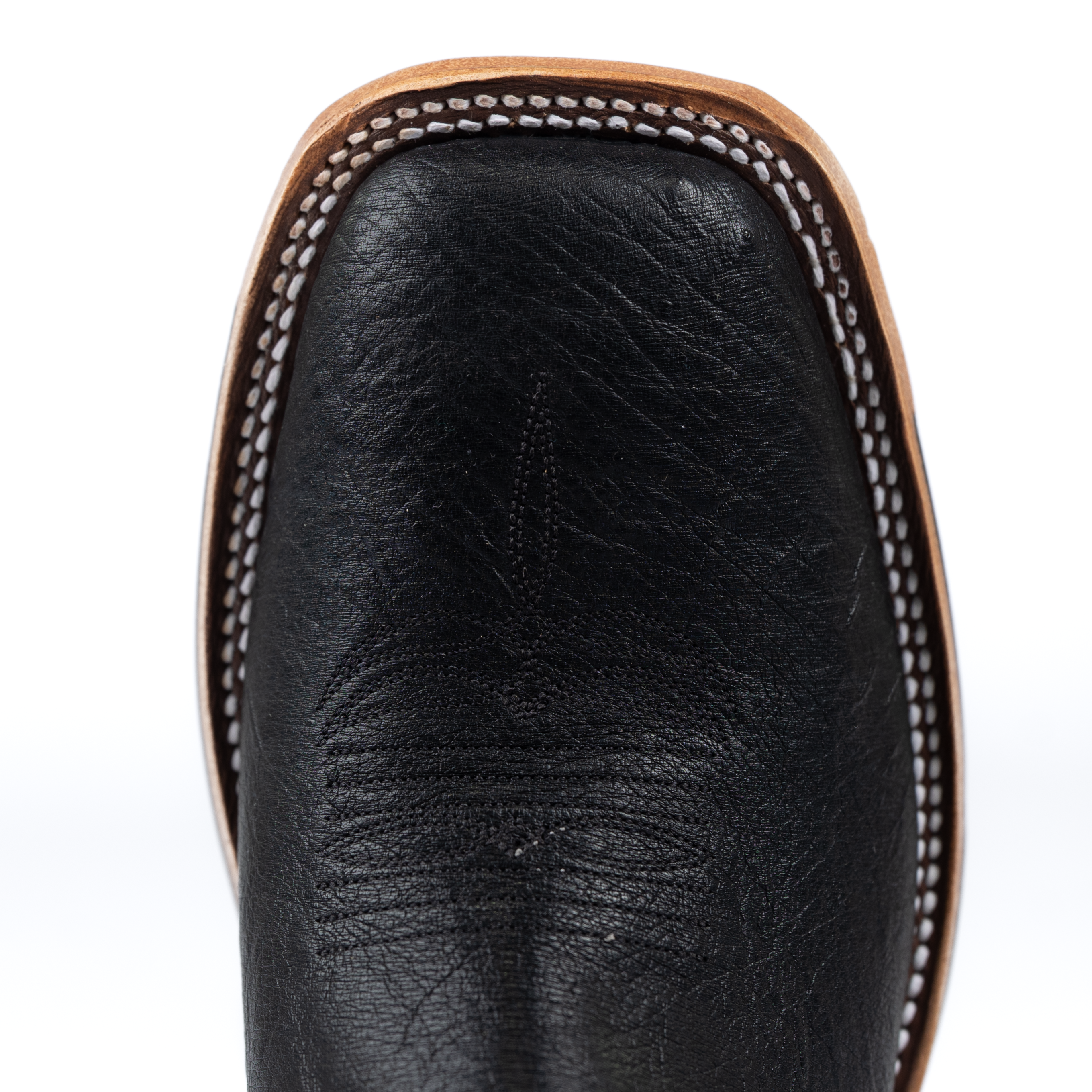 Close-up of a black leather boot with brown stitching on a white background