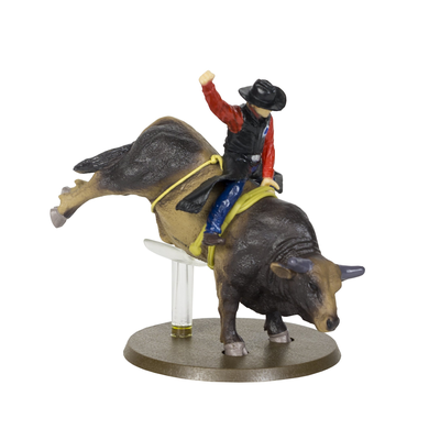 Figurine of a cowboy riding a bucking bull on a white background