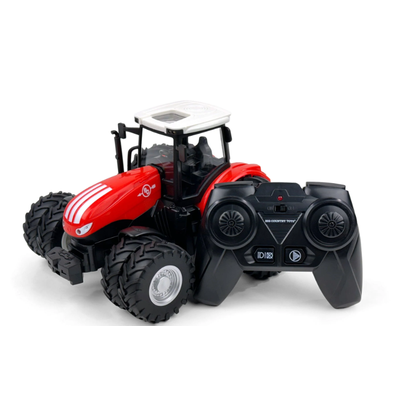 Red toy tractor with a black remote control on a white background