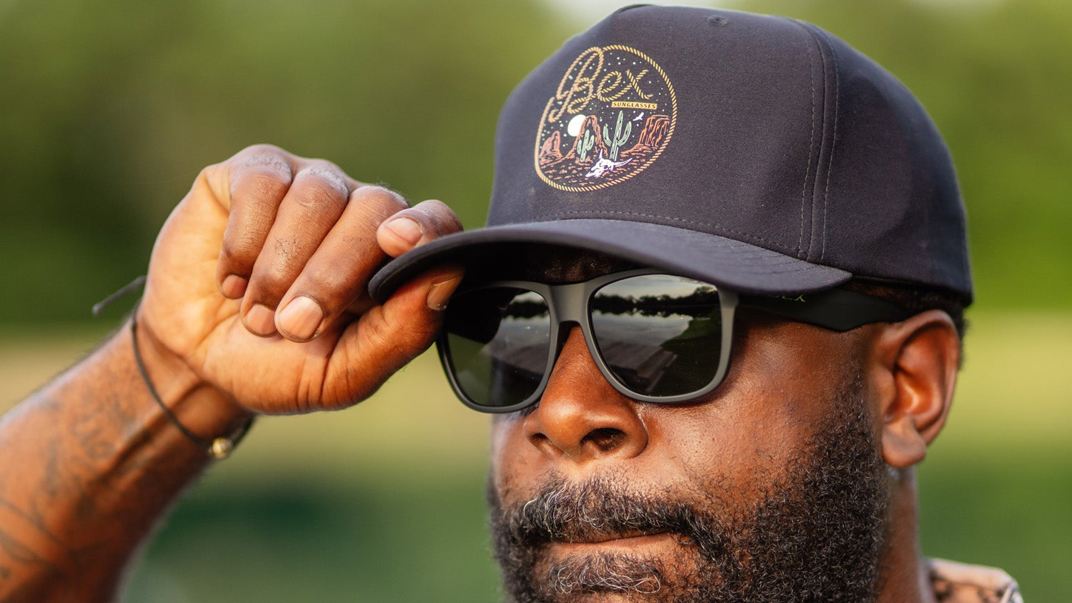 Man wearing a baseball style cap and wearing sunglasses