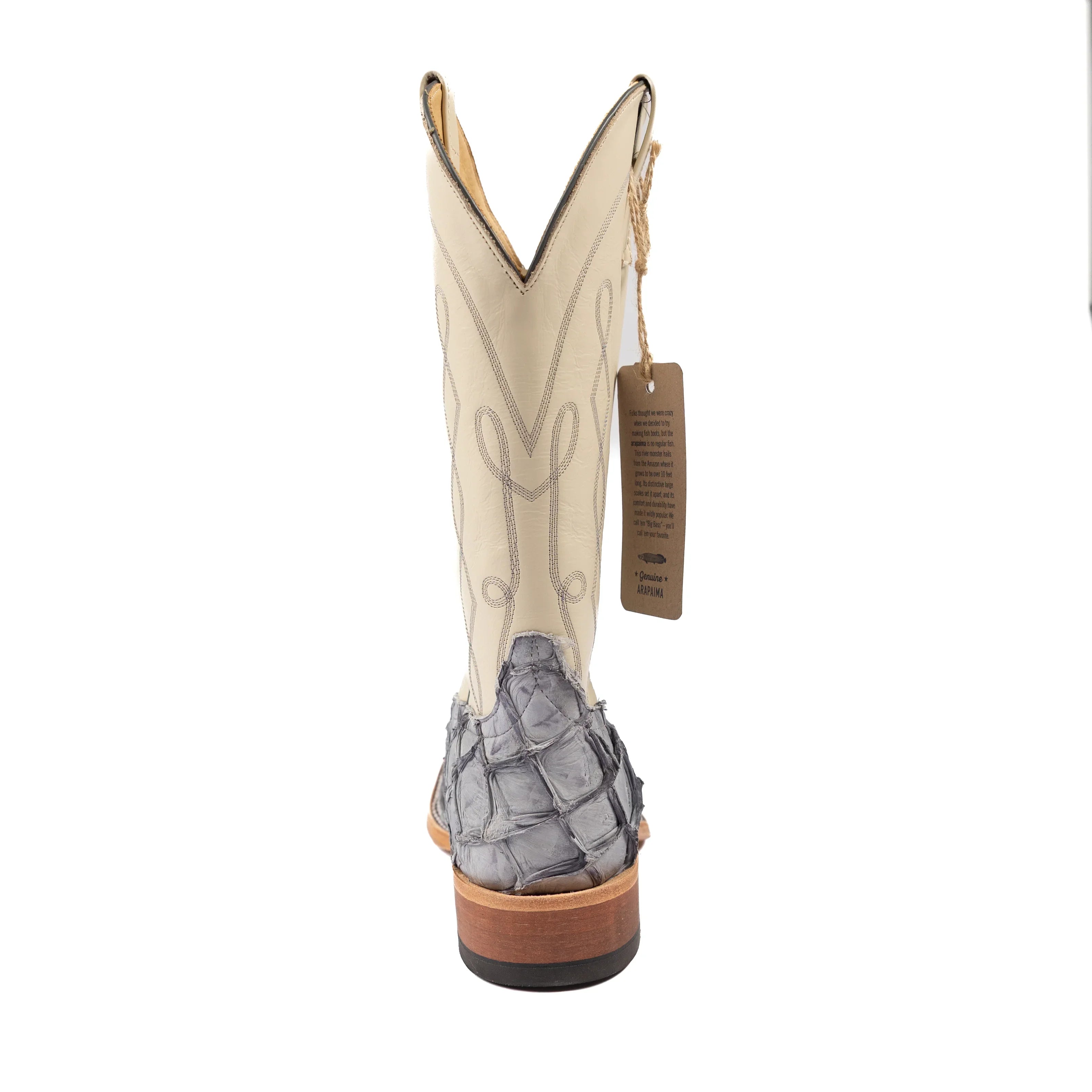 Beige cowboy boot with gray crocodile-patterned sole on a white background