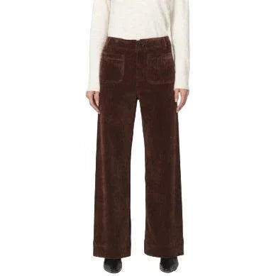 Brown corduroy pants worn by a person on a white background