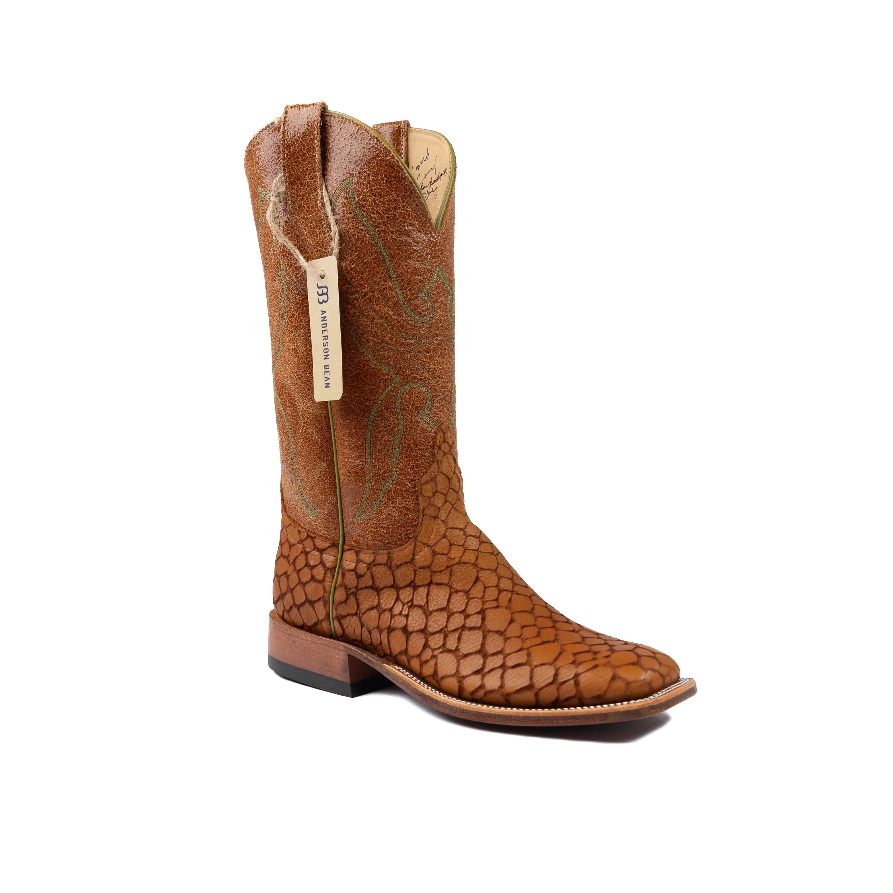 Brown cowboy boot with a textured pattern on a white background