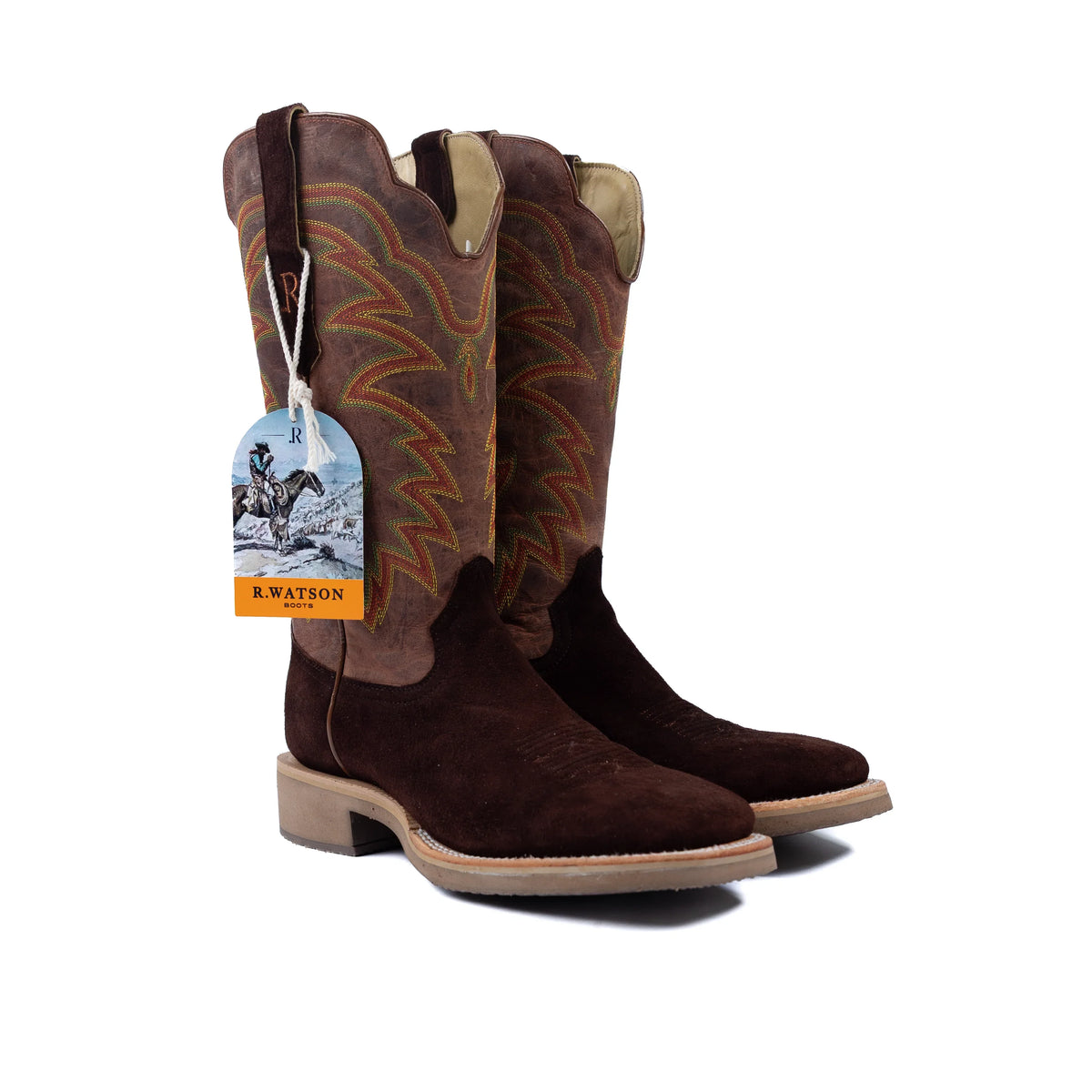 Brown cowboy boots with a tag on a white background