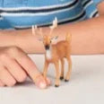 Child wearing a blue striped polo shirt with a small figurine on a white background
