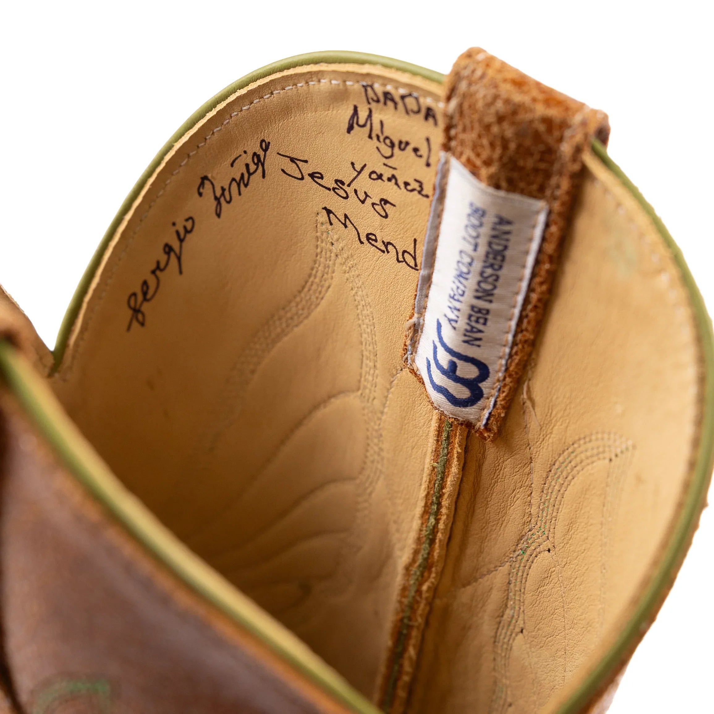 Close-up of a brown leather shoe with a brand label on a white background