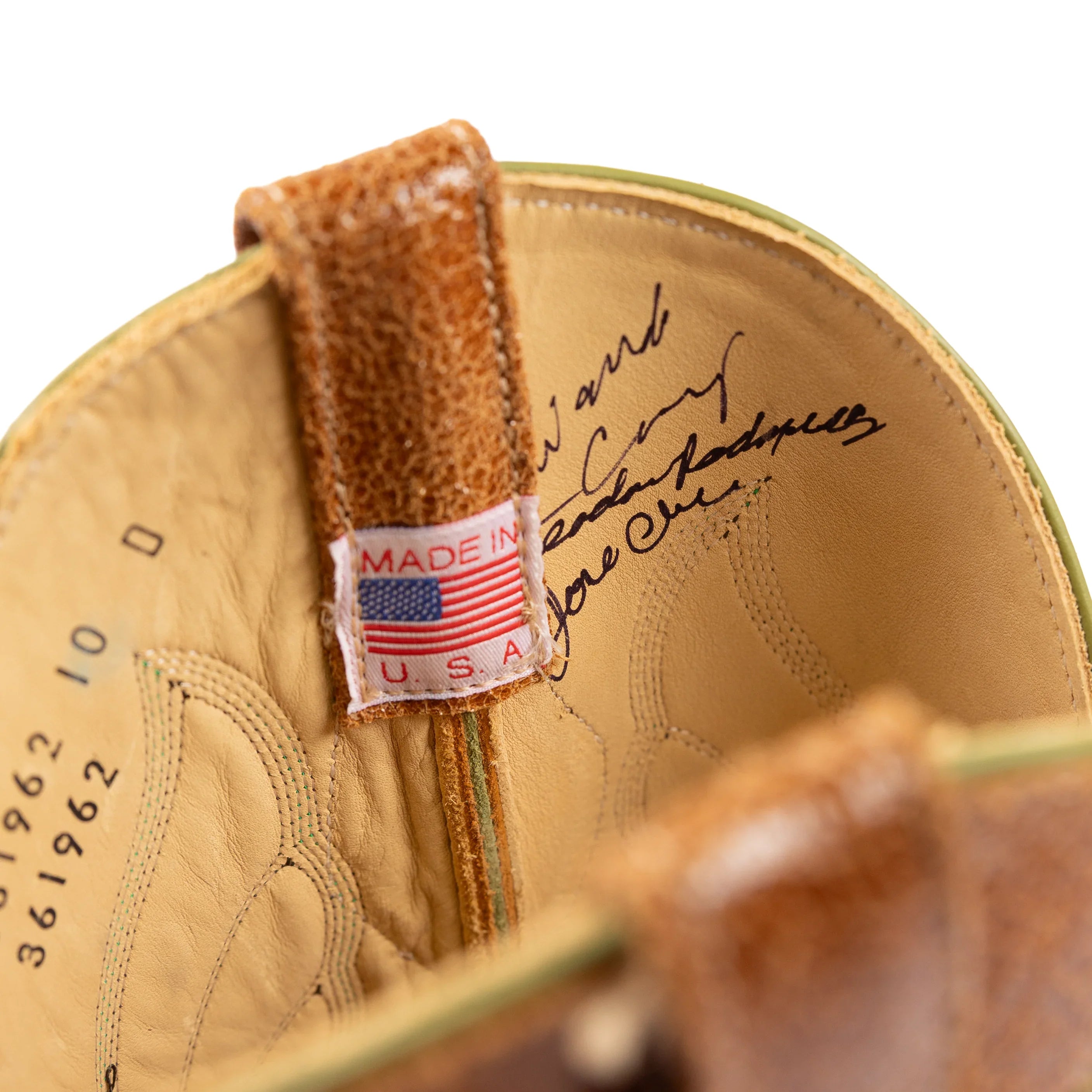 Close-up of a tan leather shoe with a 'Made in USA' tag on a white background