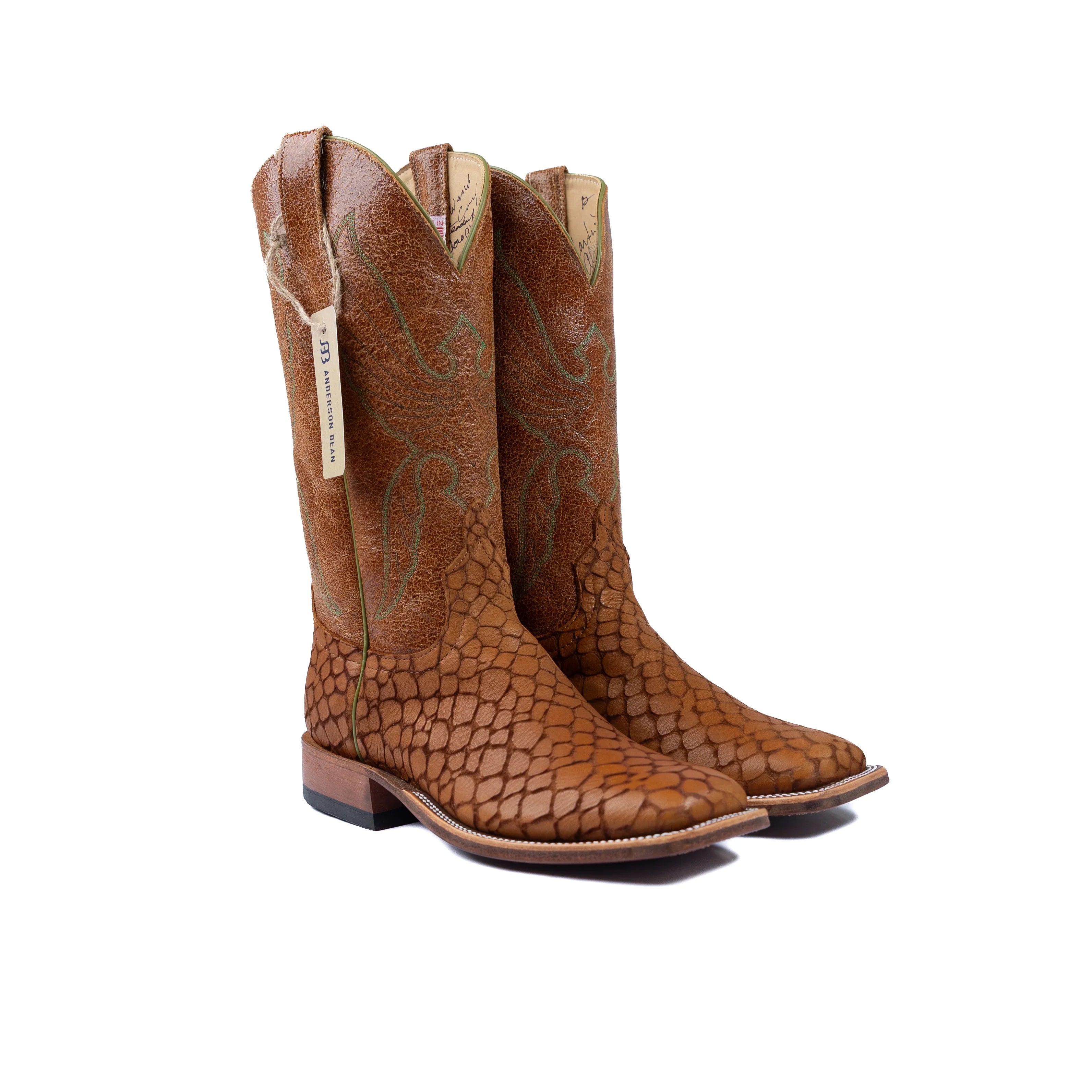 Pair of brown cowboy boots with a textured pattern on a white background
