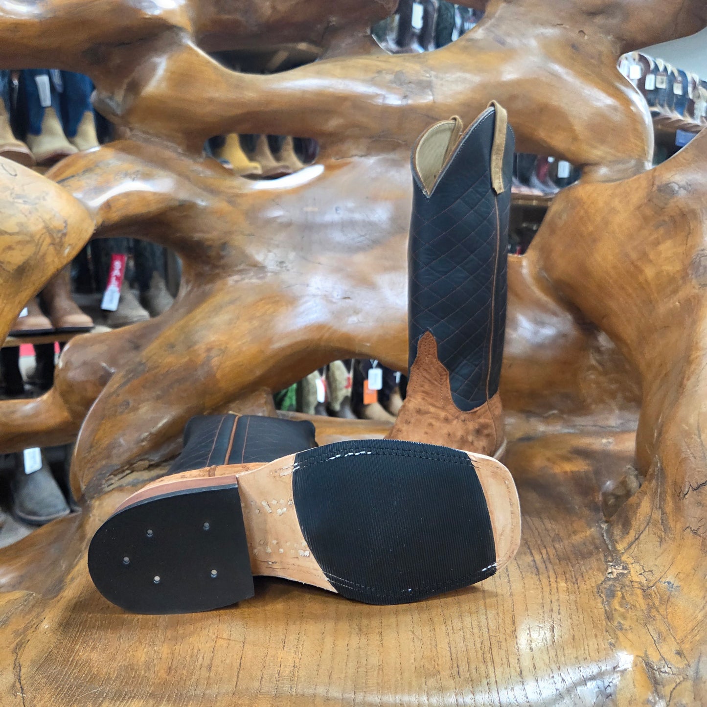 Pair of black and brown insoles on a wooden horse sculpture