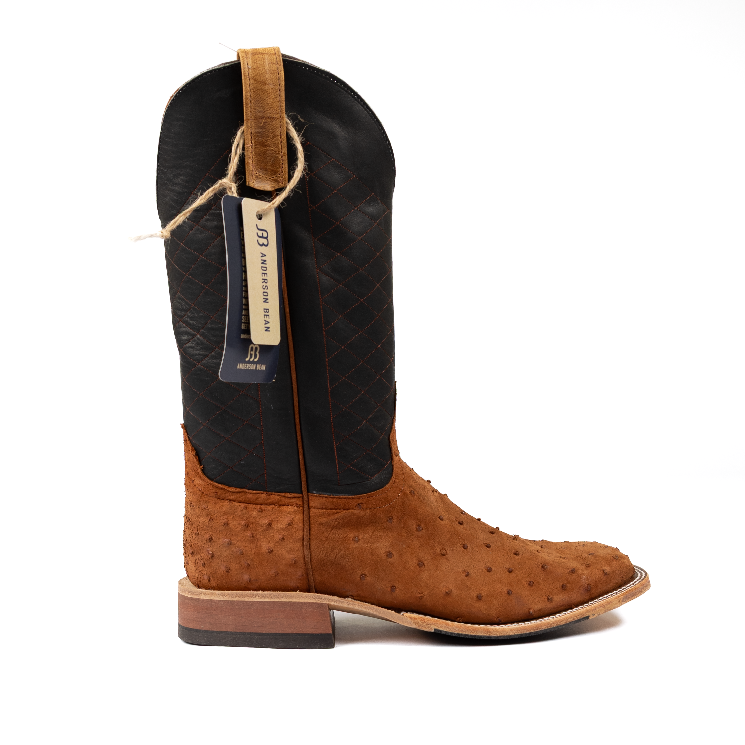 Brown and black cowboy boot with a visible brand tag on a white background