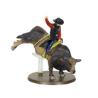 Figurine of a cowboy riding a bucking bull on a white background