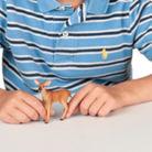 Young boy in a blue striped polo shirt holding a toy figure on a white background