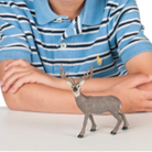 Child wearing a blue striped shirt with a small deer figurine on a white background