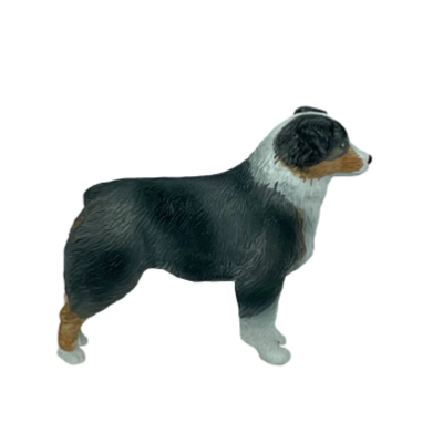 Dog figurine with black, white, and brown color pattern on a white background