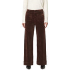 Brown corduroy pants worn by a person on a white background