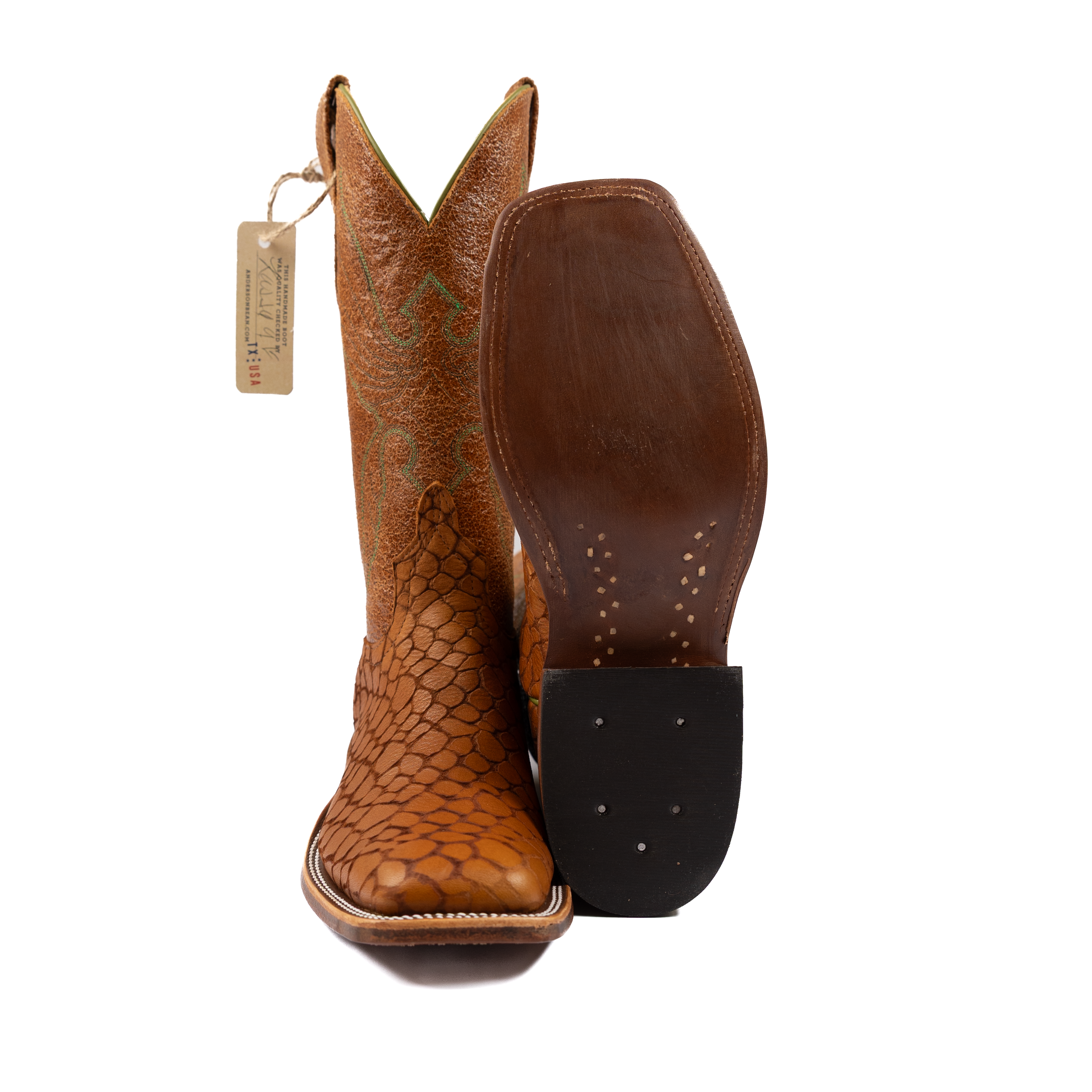 Brown cowboy boot with a textured sole on a white background